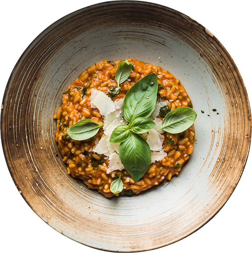 Cremiges Tomaten-Basilikum-Risotto mit gehobeltem Parmesan und frischen Basilikumblättern auf einem Keramikteller.